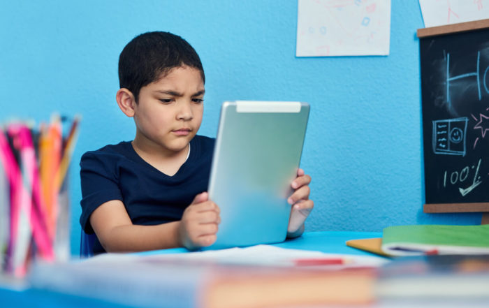 Child using iPad to learn in classroom