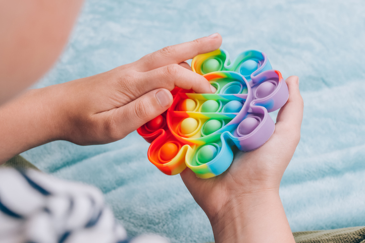 Boy playing with rainbow pop it fidget toy