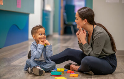Toddler patient works with female provider using hands to make f